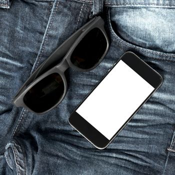 sunglasses and smartphone on jean pant concept man accessories