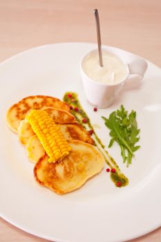 corn pancakes with cream at plate