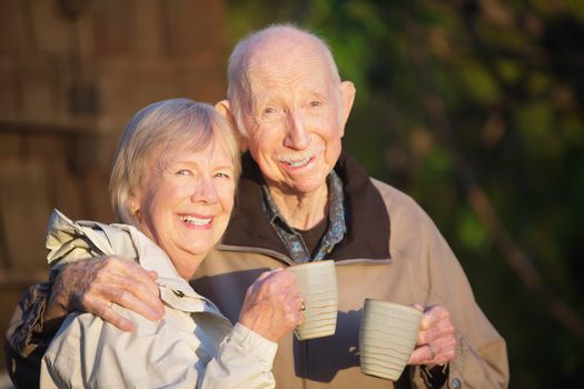 Older senior couple together outdoors holding coffee
