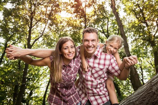 Beautiful young family enjoying a piggyback in the forest.