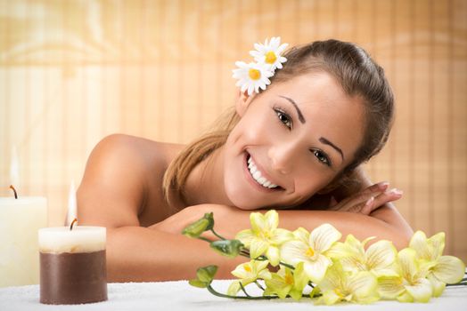 Cute young woman enjoying during a skincare treatment at a spa. She is looking at camera. 
