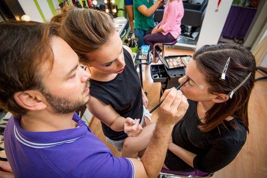 Makeup teacher helping students training to become makeup artist