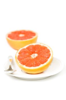 Halved red grapefruit on white