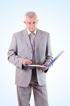 Successful Senior Businessman standing and signing documents
