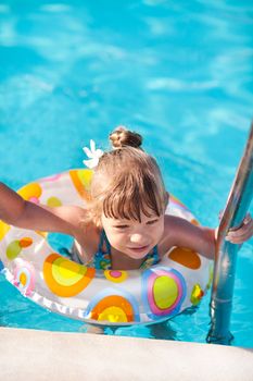 Little girl out of the pool on ladder