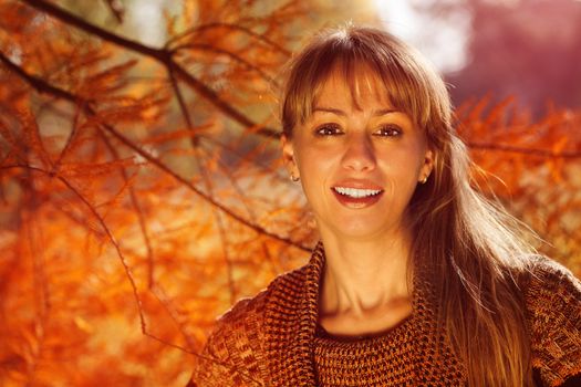Young beautiful autumn woman lighted by the sun