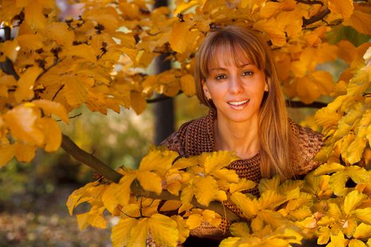 Young beautiful woman united with nature in autumn