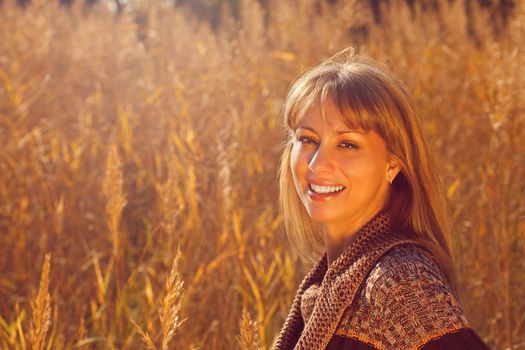 Young beautiful autumn woman lighted by the sun