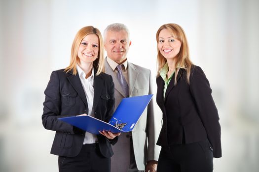 Three smiling business people standing in office