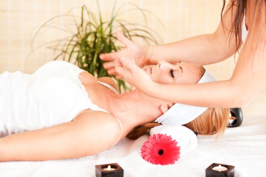 Young beautiful woman receiving head massage at the spa center