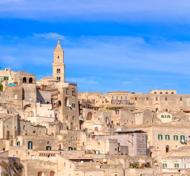 panoramic view of typical stones (Sassi di Matera) and church of Matera under blue sky. Basilicata, Italy