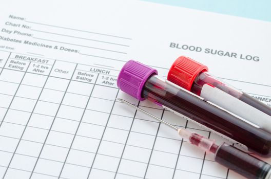 Daily blood Sugar log testing and sample blood in tube and syringe in laboratory. Blood sugar control concept.