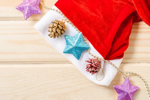 Santa Hat with Christmas decorations on wooden table