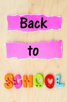 Back to school wording on wooden background.