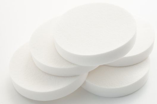 White cosmetic circle sponges for makeup on white background