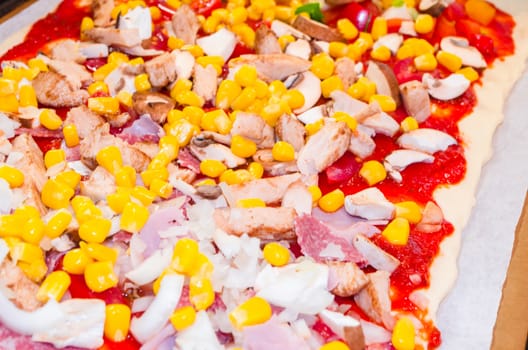 Pizza tray with different ingredients such as mushrooms, salami, cheese and tomatoes.
