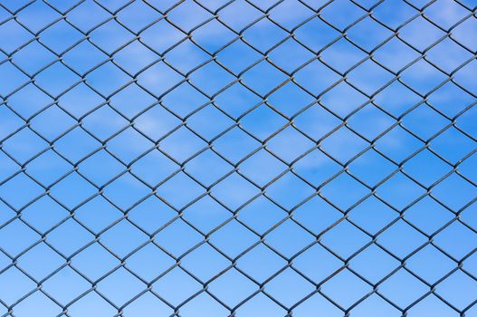 Metal mesh wire fence with blur blue background
