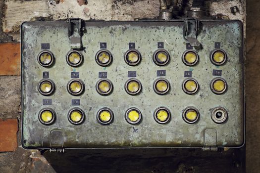 Old dirty electrical box with with push buttons in an old abandoned factory.