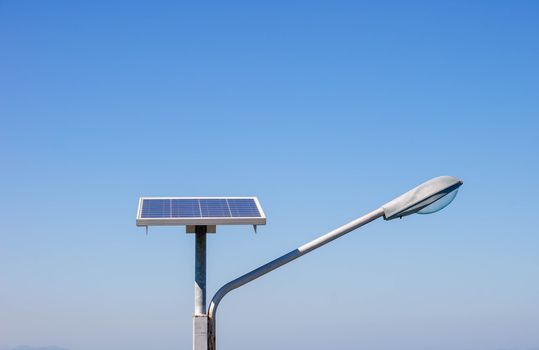 Streetlight with solar panel on blue sky background
