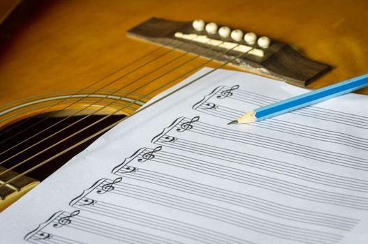 guitar and blank notebook with pen.