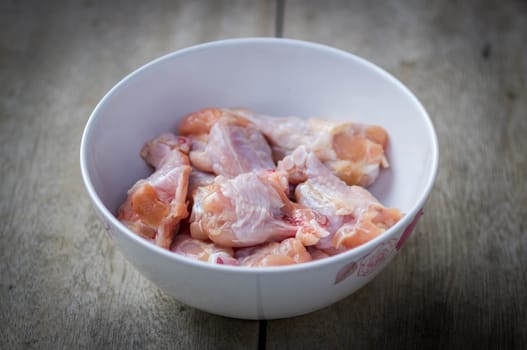 Raw chicken wings in bowl.