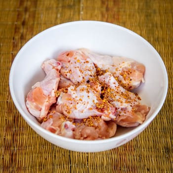 Raw chicken wings in bowl.