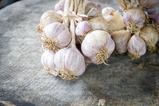 Close up of purple garlic on wooden background (Alliums, Alliaceae)