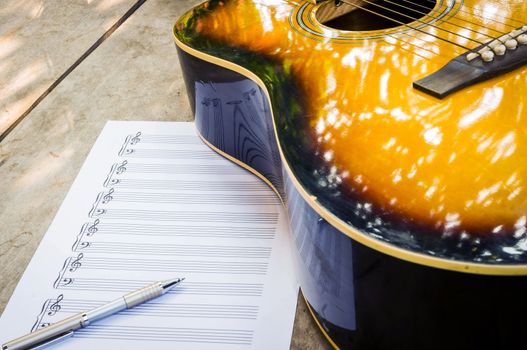 guitar and blank notebook with pen.