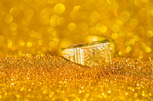 Golden Ring on bokeh gold color abstract background.