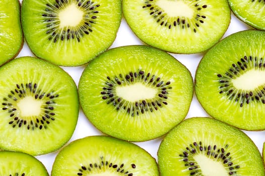 Many slices of kiwi fruit on white background.