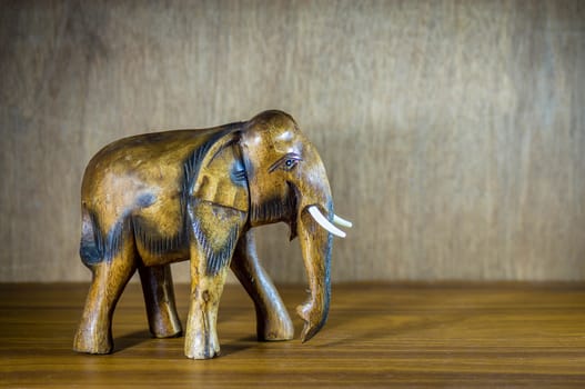 Handcraft wood elephant sculpture on wood background.
