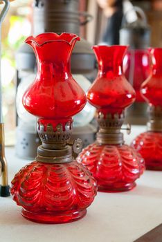 Old antique kerosene lamp with red glass color bulb.