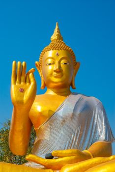 Big golden buddha statue sitting at thai temple.