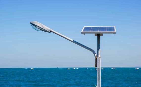 Streetlight with solar panel against sea background