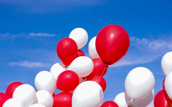 Bunch of red and white balloons on a blue sky
