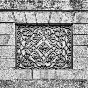 Facade of an ancient Italian villa with artistic iron grill handmade.