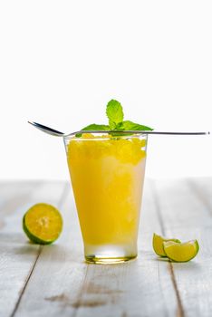 Lemon refreshing dessert in glass decorated with lemon and mint on white wood table