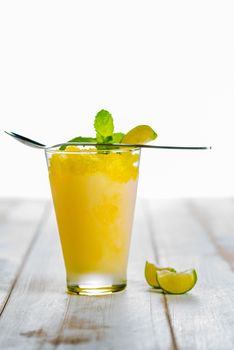 Lemon refreshing dessert in glass decorated with lemon and mint on white wood table