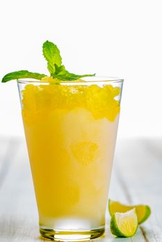 Lemon refreshing dessert in glass decorated with lemon and mint on white wood table