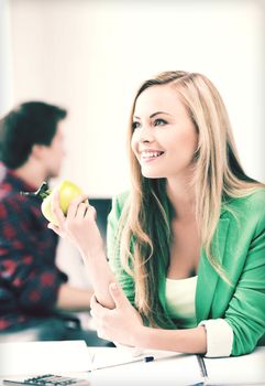 education concept - smiling student girl with green apple in college