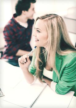 education concept - smiling student girl studying in college