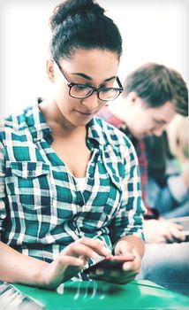 education concept - smiling international student girl with smartphone at school