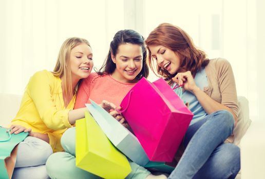 shopping and lifestyle concept - three smiling teenage girls with many shopping bags at home