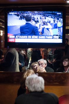 FRANCE, Paris: People watch TV in the 11th district of Paris  after an attack on November 13, 2015 in Paris, France. According to reports, over 150 people were killed in a series of bombings and shootings across Paris, including at a soccer game at the Stade de France and a concert at the Bataclan theater. 