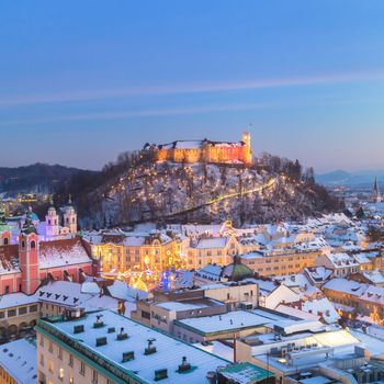 Aerial panoramic view of Ljubljana decorated for Christmas holidays. Roofs covered in snow in winter time. Slovenia, Europe. Square copmposition. Copy space.