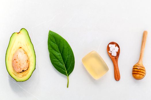 Alternative skin care  and scrub fresh  avocado , leaves ,sea salt soap and honey on marble background.