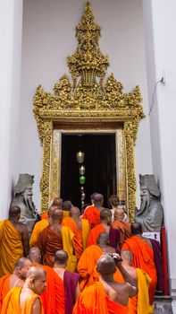 Buddhist monks enter Wat Pho, the Temple of the Reclining Buddha in Bangkok. The temple is famous of the huge gold-plated statue of Buddha measuring 15m high and 46m long.
