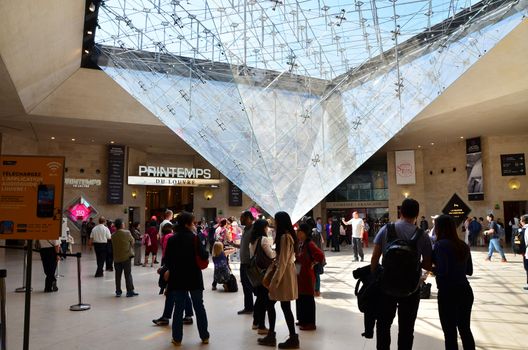 Paris, France - May 13, 2015: Tourists visit Inside the Louvres pyramid on May 13, 2015 in Paris. Louvre is one of the biggest Museum in the world, receiving more than 8 million visitors each year.
