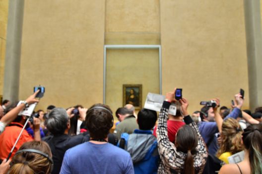 Paris, France - May 13, 2015: Visitors take photos of Leonardo DaVinci's "Mona Lisa" at the Louvre Museum on May 13, 2015 in Paris, France. The painting is one of the world's most famous, shallow depth of focus.