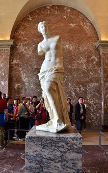 Paris, France - May 13, 2015: Tourists visit The Venus de Milo statue at the Louvre Museum in Paris. The Venus de Milo statue it's one of most important statue of the world.